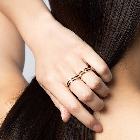 Zoom sur la main d'une femme portant la bague deux doigts Aurore en forme de spirales