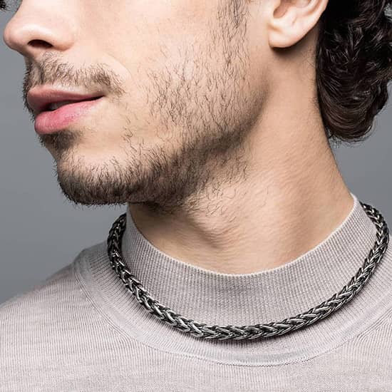 Zoom sur le cou d'un homme portant le collier Odin en chaine et cuir tressé 