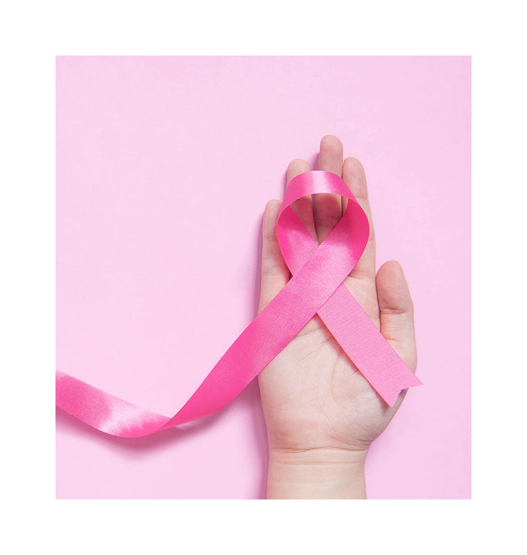 Ruban rose symbole de la lutte contre le cancer du sein posé sur une main